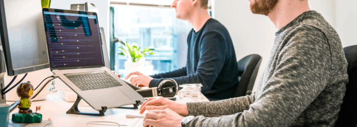 Two men in customer care with laptops working.