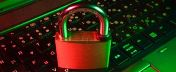 Metalen hangslot op een laptoptoetsenbord, symbool voor cybersecurity en gegevensbescherming