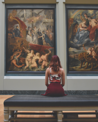 Woman sitting in front of paintings